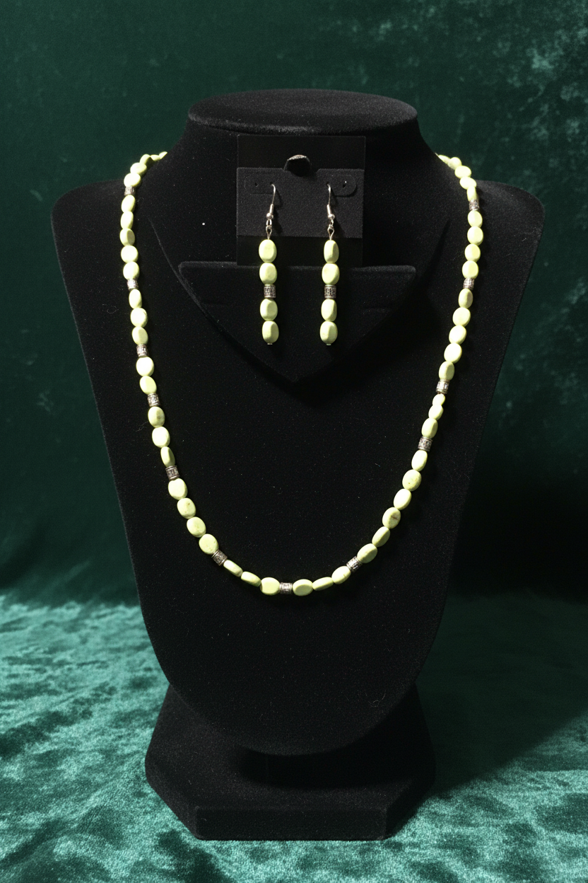 Green turquoise and silver barrel necklace set on emerald green backdrop