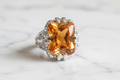 Orange quartz cocktail ring on white marble background