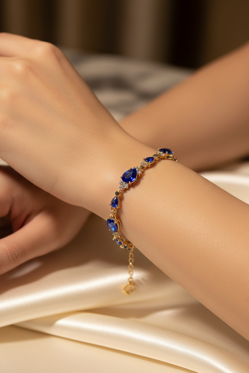 Gold plated royal blue sapphire and crystal bracelet worn on a model's wrist