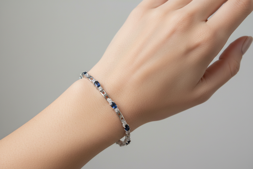 Rhodium sapphire and crystal tennis bracelet worn on model's hand