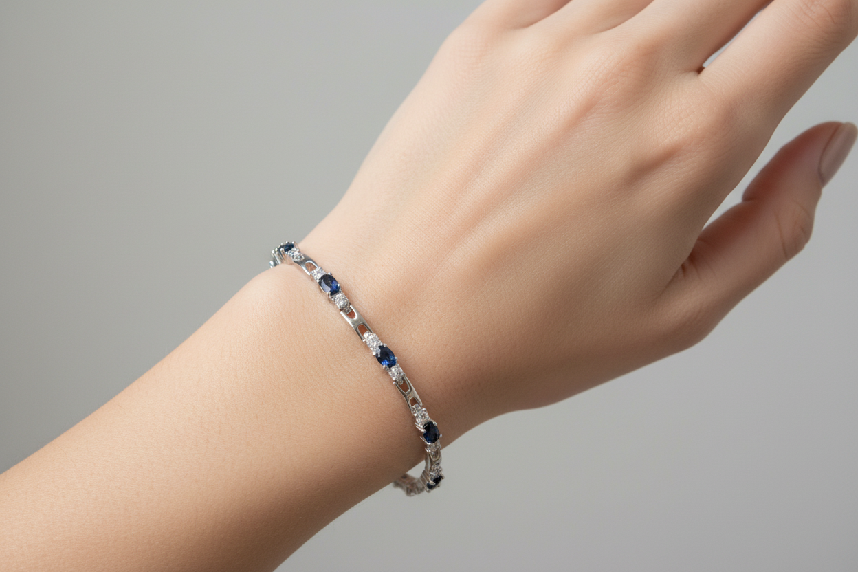 Rhodium sapphire and crystal tennis bracelet worn on model's hand