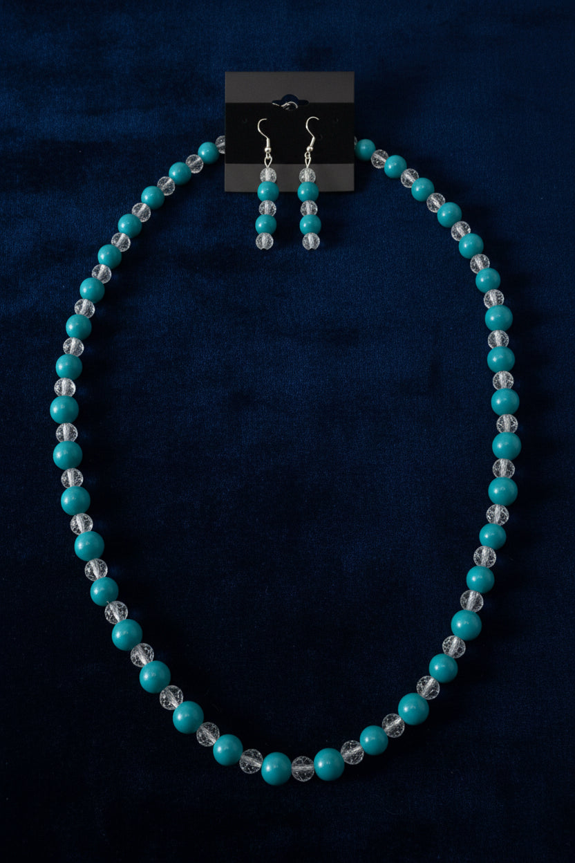 Handcrafted teal and crackle glass beaded necklace and earring set on wood surface