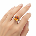 Cushion cut orange topaz ring size 7 on woman's finger white background
