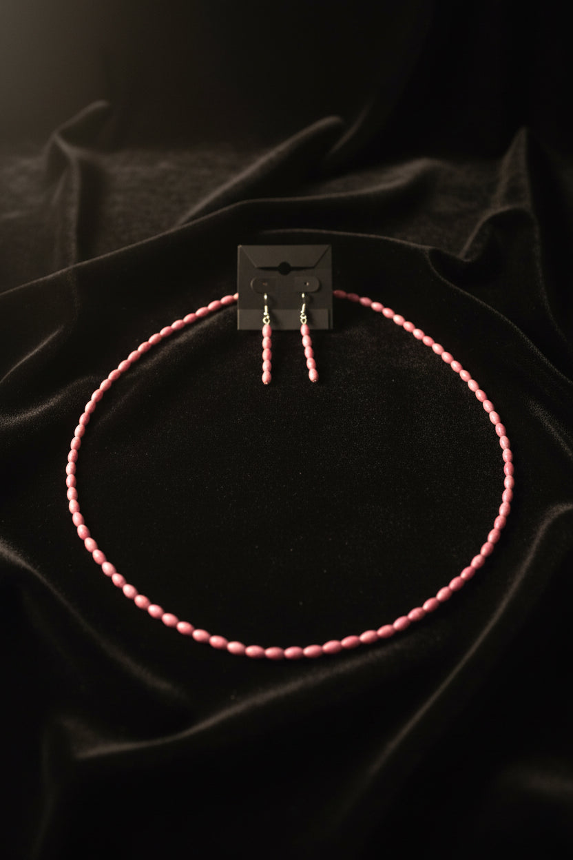 Marbled pink matrix oval bead necklace set with matching earrings on wood surface