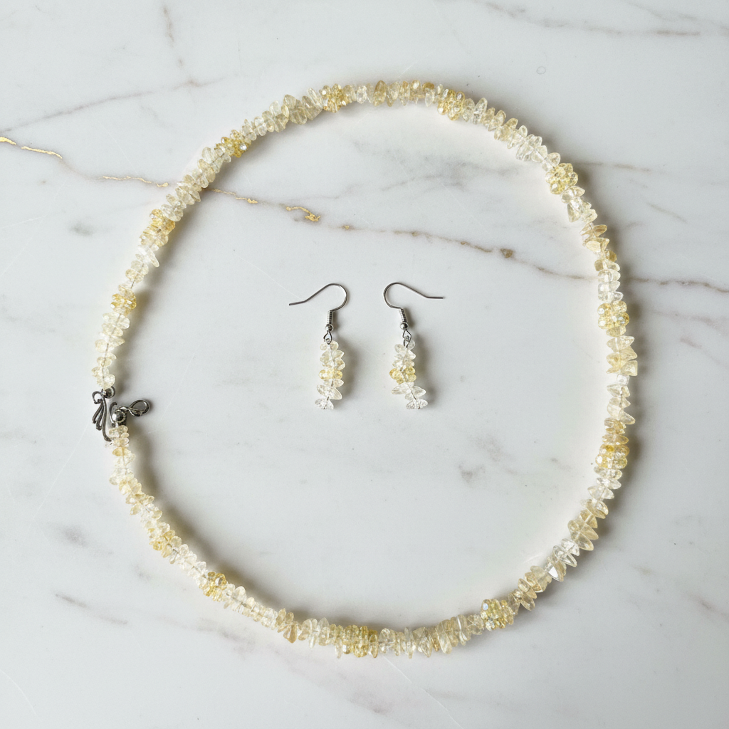Golden citrine crystal chip necklace and earring set on gold marble surface