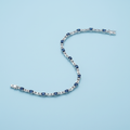 Rhodium sapphire and crystal tennis bracelet on light blue background