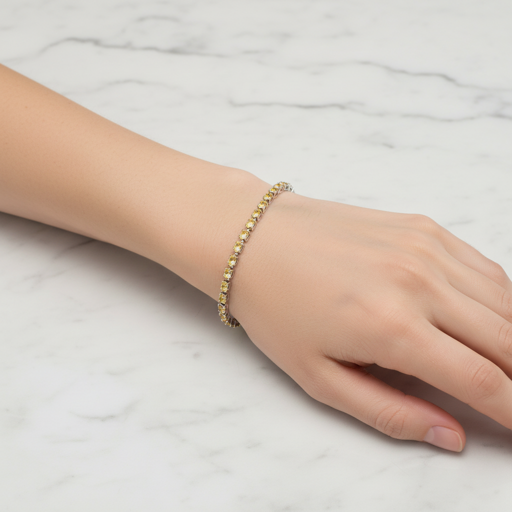 Yellow crystal tennis bracelet on model's wrist with marble background