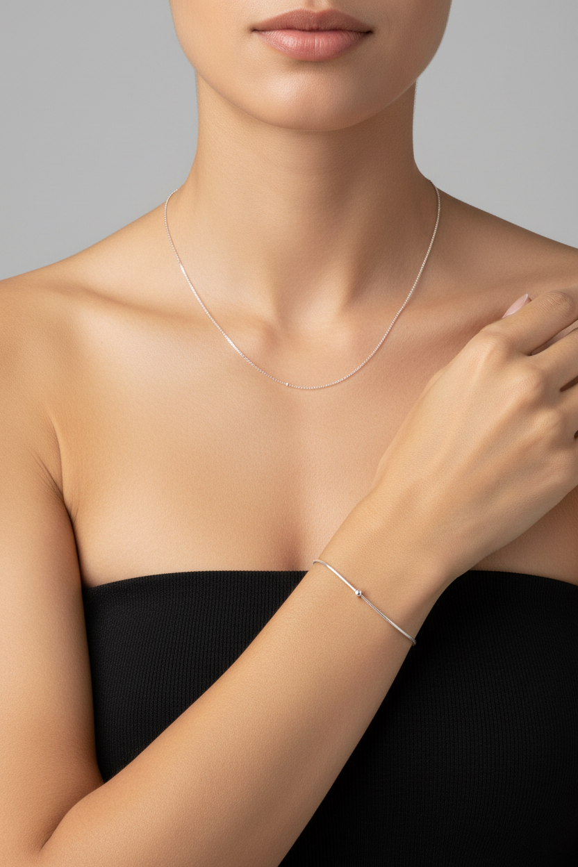 Model wearing silver necklace and bracelet set