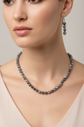 Model wearing smoky blue gray twisted acrylic cube necklace and earrings